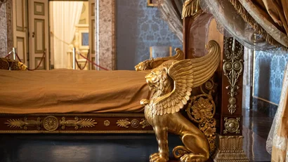 Letto antico con decorazioni dorate e figura di leone alato
