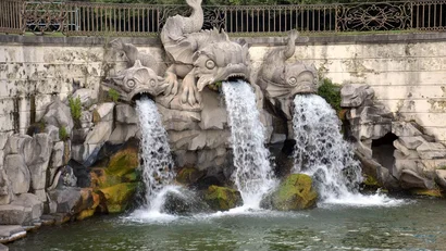 Fontana con tre sculture di pesci che spruzzano acqua in uno stagno