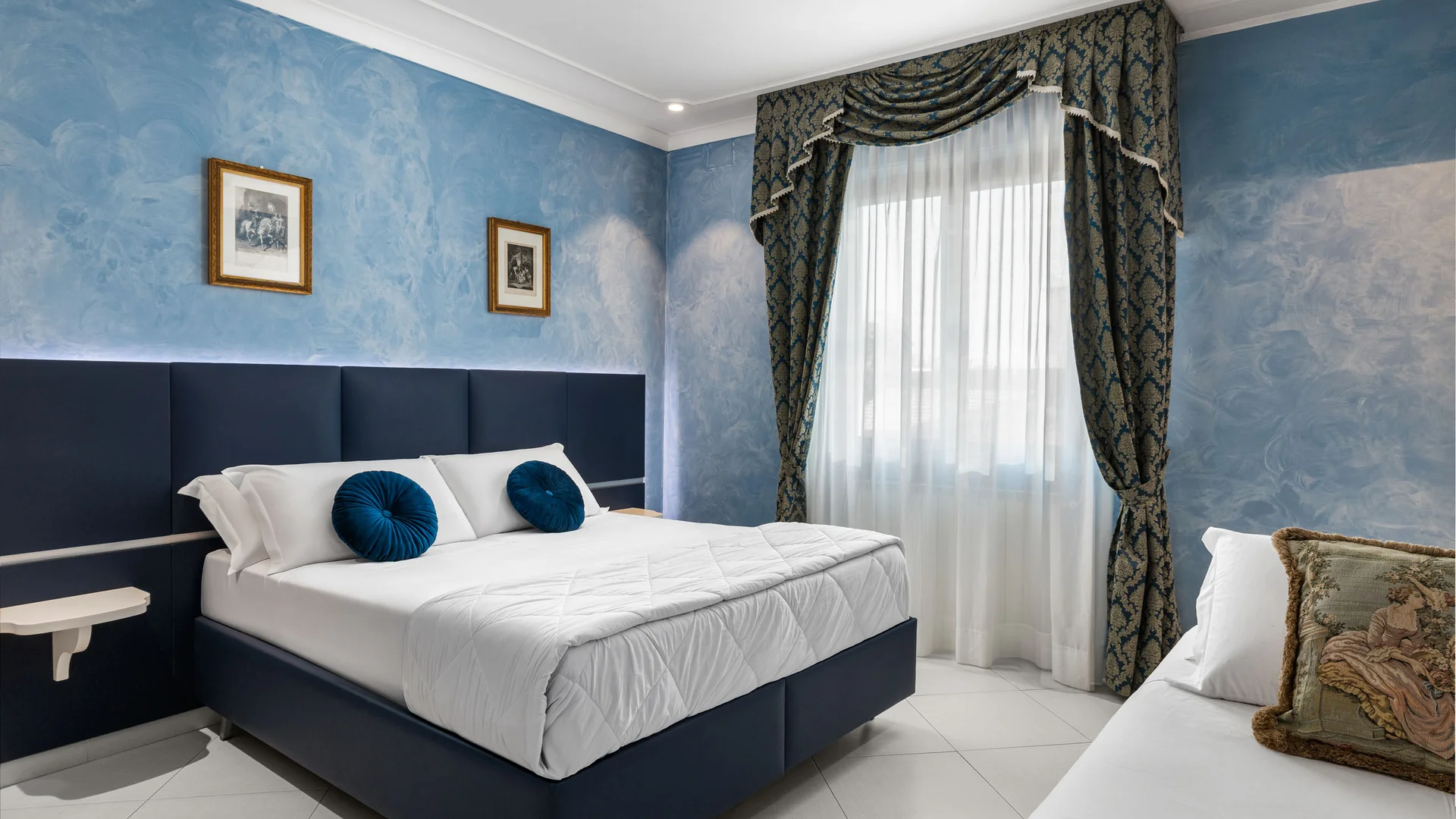 Camera da letto con letto matrimoniale, pareti azzurre e tende decorate