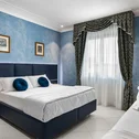 Camera da letto con letto matrimoniale, pareti azzurre e tende decorate