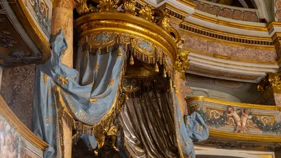 Interno di chiesa barocca con drappi blu e oro e decorazioni ornate
