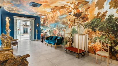 Interno di hotel con pareti e soffitto affrescati e mobili d'epoca