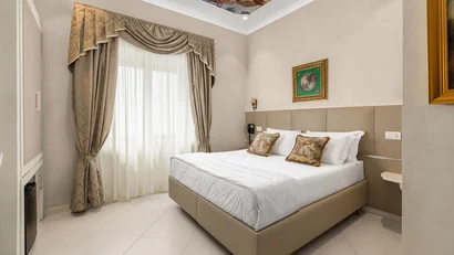 Camera da letto elegante con letto matrimoniale, tende ornate e soffitto affrescato