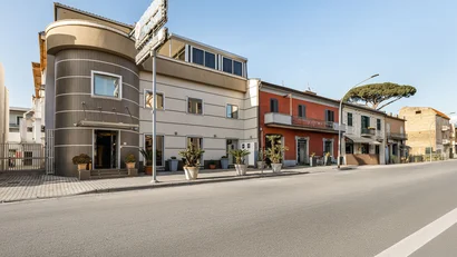 Facciata moderna di un hotel con piante in vaso lungo la strada