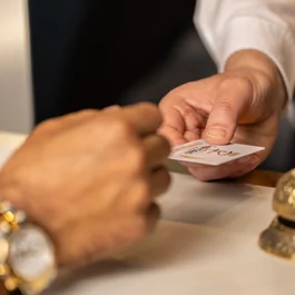 Handing over a hotel key card at reception with golden bell