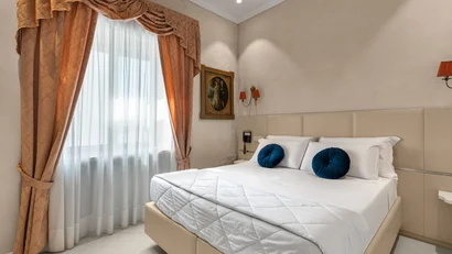 Camera da letto elegante con letto matrimoniale e tende arancioni